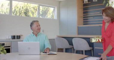 Son sınıf çifti hediye üstüne kutlama yapıyor, kadın hediye sertifikası veriyor, erkek sarılma partneri mutfakta. Kutlama, başarı, takdir, sevgi, minnettarlık, ev, modern