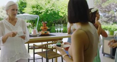 Çeşitli bayan arkadaşlar gelin adaylarını alkışlıyor, patlıyor ve verandada şampanya döküyorlar. Kutlama, dostluk, neşe, açık hava, yaşam tarzı, coşku, zarafet