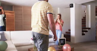 Partide, Arkadaşlar kutlama için oturma odasını dekore ediyor, masaya balon ve pasta koyuyorlar. Parti, dostluk, hazırlık, toplanma, şenlik, takım çalışması