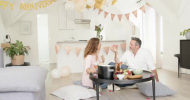 Yıldönümü afişini görmek, yaşlı çiftin flüt tokuşturması, yudumlaması ve evde hediye kutusunu açması. Romantik, kutlama, samimiyet, neşe, zarafet, modern, samimi