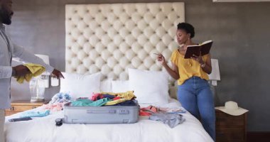 Çift yatakta bavul hazırlıyor, evde heyecanlı bir tatil için hazırlanıyor. Seyahat, bagaj, tatil, yolculuk, macera, rahatlama