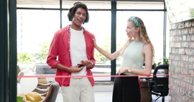 Çeşitli iş arkadaşları ofis lobisinde balonlarla el çırparken kırmızı kurdeleyi makasla kesiyor. Büyük açılış, açılış, tören, kutlama, takım çalışması, başarı, modern