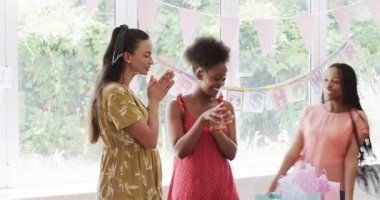 Çeşitli bayan arkadaşlar, anne adayının evine örttükleri hediyelerden kuşak çıkarıyorlar, fotokopi çekiyorlar. Kutlama, arkadaşlık, annelik, evcil, neşeli, neşeli, dekor