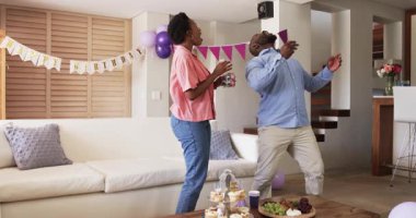 Evde doğum günü kutlaması, kadın abur cubur hazırlarken erkek içki hazırlıyor. Kutlama, parti, festival, birliktelik, hazırlık