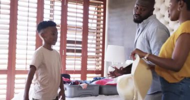 Aile tatil için bavul hazırlıyor, gülümsüyor ve evde birlikte vakit geçiriyoruz. seyahat, birliktelik, bağ, mutluluk, hazırlık