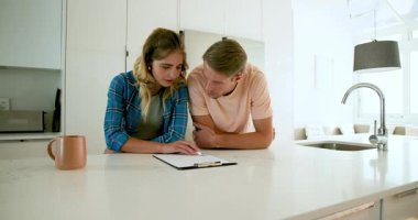 Çiftler modern mutfakta belgeleri gözden geçiriyorlar, günlerini evde planlıyorlar. Yaşam tarzı, takım çalışması, organizasyon, günlük, ev, evrak işleri