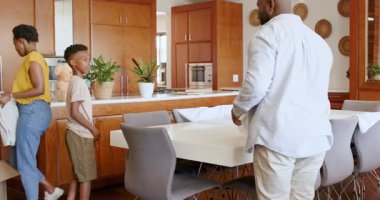 Aile mutfakta eğleniyor, yastıkları atıyor ve birlikte gülüyorlar, evde. Bağlanma, ev, kahkaha, mutluluk, birliktelik, yaşam tarzı