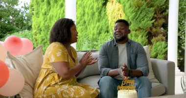 Yıldönümünü kutluyoruz, Afrikalı Amerikalı bir çift verandada pasta paylaşıyor, mutlu hissediyorlar. Kutlama, aşk, ilişki, mutluluk, açık hava, yaşam tarzı