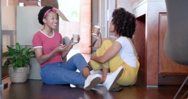 Evde kutuları açıyor, çeşitli kadın çiftler kahve içip sohbet ediyorlar. Taşınma, taşınma, yaşam tarzı, arkadaşlık, gelişigüzel, bağlanma