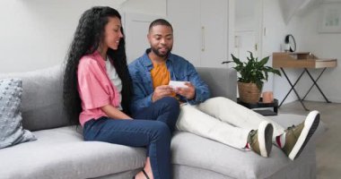 Farklı çiftler kart okuyor ve oturma odasındaki gri koltukta haberleri kutluyorlar. Şefkat, samimiyet, arkadaşlık, huzur, modern, samimi, duygusal