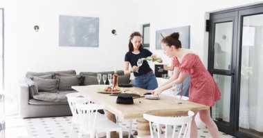 Çeşitli bayan arkadaşlar yemek salonuna giriyor, bardakları alıyor, şarap dolduruyor ve kutluyorlar. Kutlama, arkadaşlık, sosyalleşme, sıcak, kırsal, neşeli, boş zaman