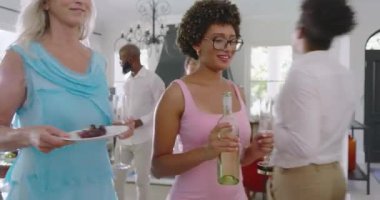 Çeşitli misafirler bardakları düzenler şişeleri toplar şarabı doldurur abur cuburları oturma odasına taşır. Kutlama, sosyalleşme, zarafet, diyalog, neşe, rahatlık, dostluk.