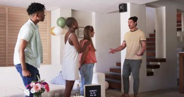 Arkadaşlar evde kutlama yapıyor, balonlar ve çiçeklerle alkışlıyor ve gülümsüyor. Kutlama, parti, mutluluk, arkadaşlık, neşeli, neşeli