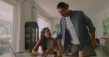 Ortaktan kahve fincanı almak, yemek masasında faturaları gözden geçirmek. İşbirliği, takım çalışması, yerli, gündelik, iletişim, rahatlama, organizasyon