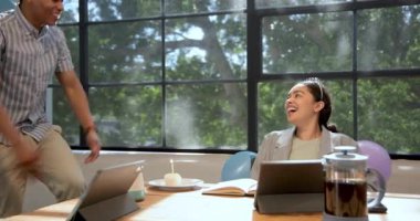 Ofisteki balonlarla süslenmiş iş kadınına mumlu kek veren mutlu bir işadamı. Doğum günü, parti, eğlence, kutlama, iş, ofis ve iş ortamı kavramı.