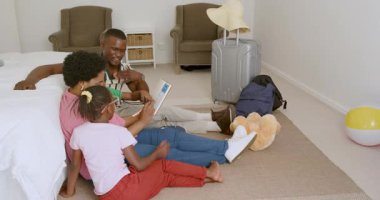 Afro-Amerikan aile kitapları okurken rahat bir dinlenme odasında, mutlu anları paylaşıyorlar. Aile, okuma, birliktelik, rahatlık, sıcaklık, konfor, bağ, ev