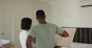 Çeşitli çiftler, dekorasyon için yatak odasının duvarına branda çekip asıyorlar. Yaşam alanı, iç tasarım, ev yenileme, modern, minimalist, takım çalışması, kutlama