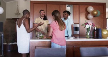 Modern mutfakta birlikte yemek hazırlarken arkadaşlar sohbetten zevk alıyorlar. Yemek pişirme, takım çalışması, arkadaşlık, aşçılık, yaşam tarzı, kaynaşma