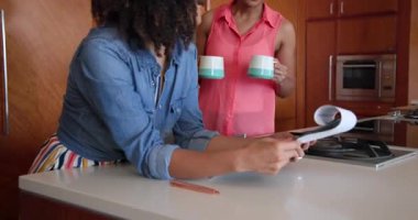 Mutfakta birlikte belge okuyorlar, çeşitli kadın çiftler gülümsüyor ve evlerinde anı paylaşıyorlar. Arkadaşlık, yaşam tarzı, birliktelik, bağlanma, sohbet, mutluluk.