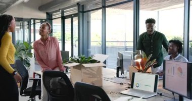 İki Afro-Amerikalı kadın, fabrikaları ve dekorasyon masalarını boşalttıktan sonra. İşbirliği, çeşitlilik, yaratıcılık, çalışma alanı, yeşillik, modernlik, takım çalışması