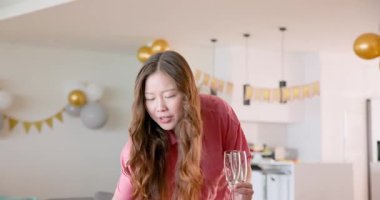 Çeşitli arkadaşlar modern mutfak tezgahını dekore ediyor, balonları düzenliyor ve doğum günü afişlerini hazırlıyorlar. Kutlama, balonlar, mutfak, arkadaşlık, dekorasyon, canlı, modern, parti