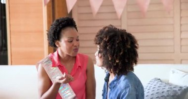 Afro-Amerikalı kadınlar kutlama sırasında pasta paylaşıp gülümsüyorlar. Arkadaşlık, mutluluk, bağlanma, lezzet, tatlı, toplanma