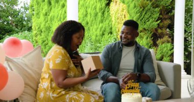 Dışarıda kek ve balonlarla oturan bir çift, yıldönümlerini birlikte kutluyorlar. Kutlama, aşk, romantizm, parti, ilişki, mutluluk