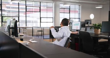 İş kadını ve iş adamı modern ofiste bilgisayar kullanıyor, tezahürat yapıyor ve beşlik çakıyor. İş, iş ve ofis ortamı kavramı.