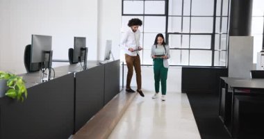 Mutlu iş kadını ve işadamı tablet kullanıyor ve ofiste konuşuyor. İş, iş ve ofis ortamı kavramı.