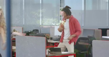 Çeşitli meslektaşlar parlak ofisteki ekip üyelerini kağıt ve yeşil bitkilerle tebrik ediyor. Kutlama, takım çalışması, başarı, coşku, işbirliği, işyeri, üretkenlik