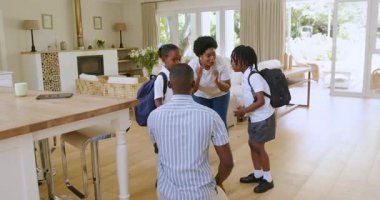 Geniş, modern bir evde aile içi etkileşim, cep telefonu ve okul çantaları. Etkileşim, çağdaş, samimi, ebeveynlik, kardeşler, iletişim, parlaklık, ev