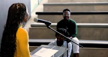 Afrika kökenli Amerikalı bir adam modern çalışma alanında genç Afrikalı Amerikalı bir kadınla kâğıtla sohbet ediyor. Etkileşim, işbirliği, tartışma, modern, takım çalışması, yaratıcılık, bağlılık