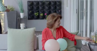 Olgun erkek ve son sınıf öğrencisi 50 süs eşyasının yanında şarap kadehlerini tokuşturup altın hediyeler açıyor. Kutlama, yıldönümü, açık hava, rahat, zarafet, arkadaşlık, neşe