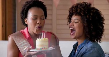 Heyecanlı kadın çift evde hediyelerini paylaşıyor, neşeli sürprizler ve kahkahalar paylaşıyorlar. Kutlama, arkadaşlık, mutluluk, hediye değişimi, bağlanma, tatil