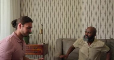 Çeşitli erkek meslektaşlar konuşmak için dinlenme odasında eğiliyor ve konuşuyor ve diğerleri de su kenarında dinliyor. Konuşma, akıl hocalığı, iletişim, yansıma, profesyonel, modern, işbirliği