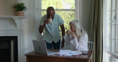 Çeşitli üst düzey çiftler, ev ofisteki galibiyetlerini dizüstü bilgisayarları ve çizelgeleriyle kutluyor. İşbirliği, başarı, refah, akıl hocalığı, başarı, motivasyon, pozitiflik