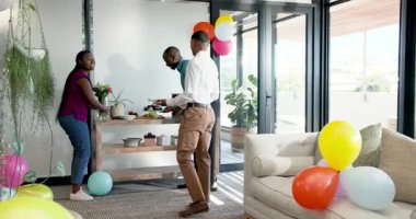 Çeşitli iş arkadaşları ofis etkinliğini kutluyor, masa yemekleriyle etkileşime giriyor ve hareketli konuşuyorlar. Kutlama, iş arkadaşları, etkileşim, toplanma, canlı, şenlikli, takım çalışması