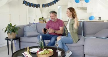 Kucaklaşan çiftin evde selfie çekmesini, doğum günü afişlerinin arasında kek paylaştığı anı takip ediyorum. Romantik, kutlama, samimi, samimi, mutlu, samimi, neşeli