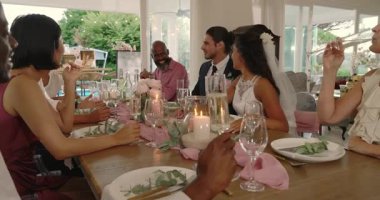 Çeşitli çiftler resepsiyona bakıp flüt kaldırıyor, konuklar kadeh tokuşturuyor. Kutlama, zarafet, sosyal toplantı, köy, neşe, lüks, konukseverlik