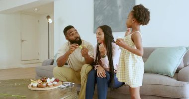 Çeşitli aileler, modern oturma odasındaki kanepede yeni kardeşlerini anons ediyor. Kekleri ve eğlenceyi paylaşıyorlar. Aile, duyuru, mutluluk, kutlama, modern, birliktelik, iç mekan, neşe