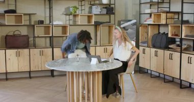 Modern sergi salonundaki mermer masada oturmuş tabletle fikirleri tartışan çeşitli çiftler. Modern, iç mekan, sohbet, ilişki, stil, ticaret, ortaklık