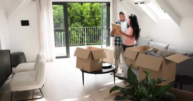 Balkon kapısı açılıyor, çeşitli çiftler kutuları taşıyor ve oturma odası hazırlıkları için mobilyaları açıyor. Konut, iç mekan, dekor, modern, konforlu, yaşam tarzı, düzenleme