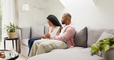 Oturma odasındaki kanepede oturan çift akıllı telefonlara el sallıyor, akıllı telefonları dinliyor, selfie için poz veriyorlar. Gündelik, rahatlama, modern, bağlantı, sevgi dolu, yaşam tarzı, ev dekorasyonu