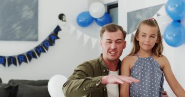 Karısının evde yemek masasında 30 mum yakarak doğum günü pastasını taşıdığı çeşitli aile kucaklaşması. Şenlik, kutlama, birliktelik, neşe, iç mekan, neşe, kilometre taşı