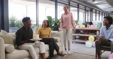 Afro-Amerikalı arkadaşlar ofis salonunda toplanıp doğum günü kutluyor, pasta tutuyor ve gülümsüyorlar. Şenlikli, yoldaşlık, sosyalleşme, neşeli, modern, kırsal, pastel