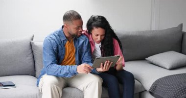 Muhtelif çiftlerin kanepe üzerindeki tabletlere dokunarak satın alma işlemini tamamladıkları yerde. Teknoloji, işbirliği, dijital, yaşam tarzı, modern, bağlantı, tüketici