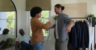 Erkek terzi, yatak odasına sığmak için göğüs stilisti ceketine mezura bağlıyor. Stüdyo, moda, zanaat, yoldaşlık, gündelik, yaratıcı, toplum