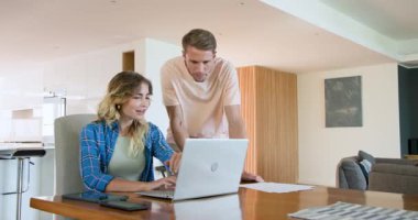 Evde dizüstü bilgisayarla çalışan çift, birlikte projeye odaklanmış. İşbirliği, takım çalışması, teknoloji, iletişim, üretkenlik, dijital