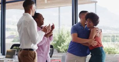 Çeşitli meslektaşlar modern ofiste yürüyor ve kutluyor, doğal ışığın ve açık alanın tadını çıkarıyorlar. Kutlama, takım çalışması, mutluluk, işbirliği, modern, çalışma alanı, profesyonel
