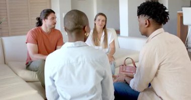 Partide, arkadaşlar evde dinleniyor, gülümsüyor ve rahat koltukta sohbet ediyorlar. Arkadaşlık, rahatlama, rahatlama, mutluluk, samimiyet, bağ.